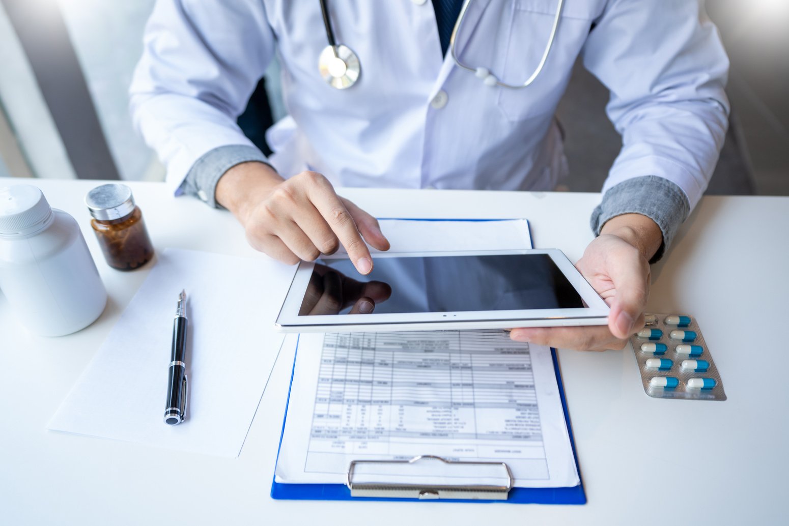 Doctor Reading a Document Report on Tablet